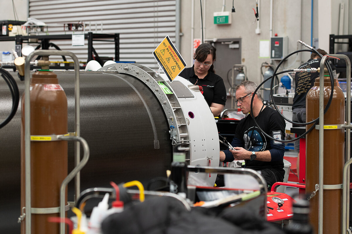 Rocket lab's Auckland Production Centre.  Detail of staff  examining inside of Electron rocket.