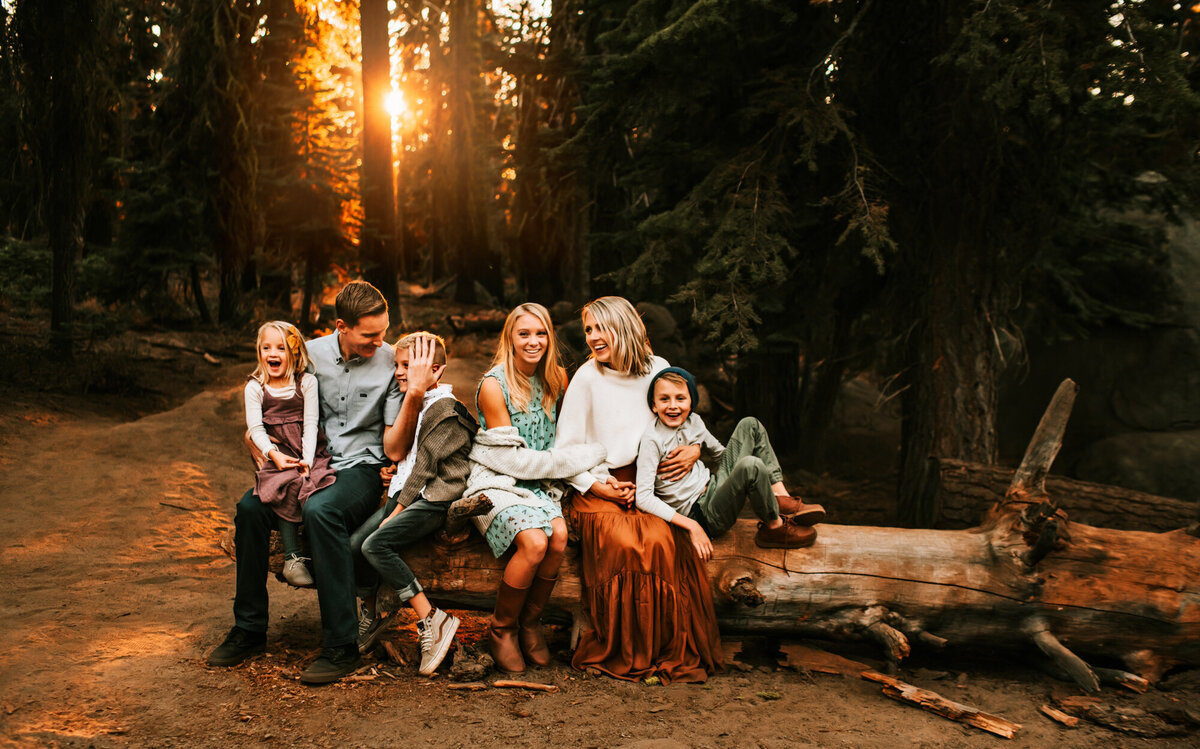 Family sitting on a log in the sunset at Yosemite.