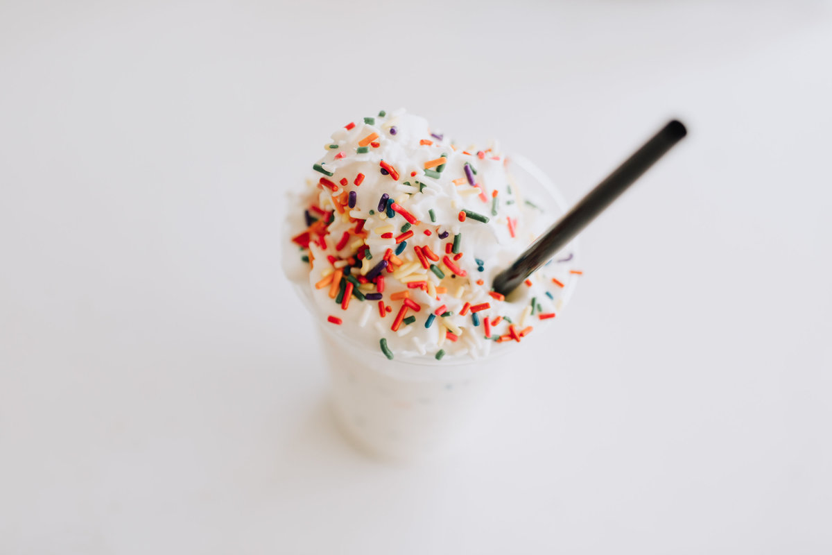 minimalist milkshake with sprinkles and straw photograph