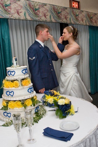My husband and I feeding each other wedding cake at our wedding.