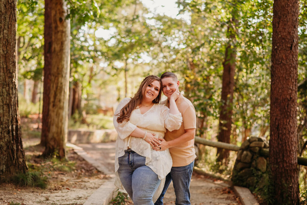 photo of man and woman cuddling in woods