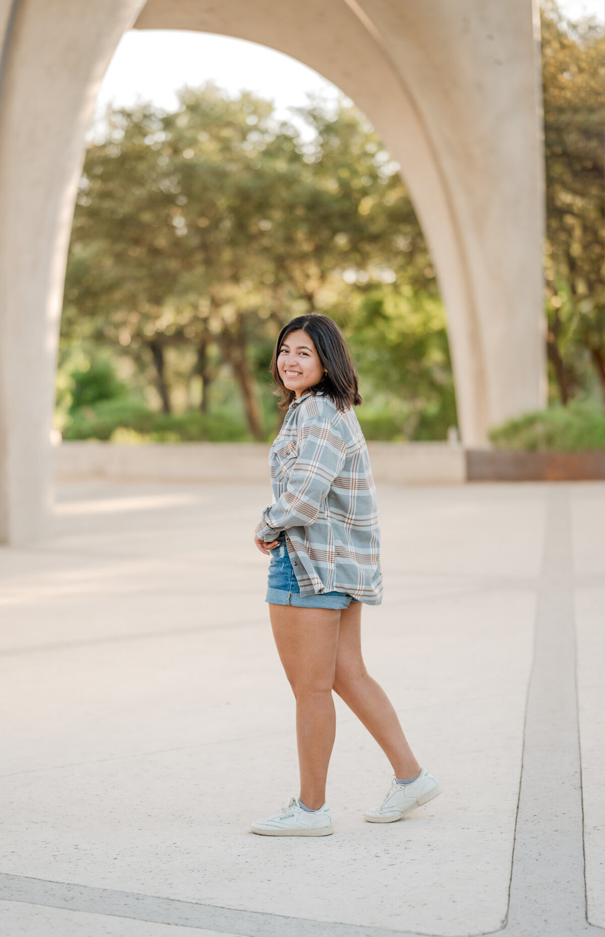 Girl walks under the arches at Confluence Park during senior pictures.