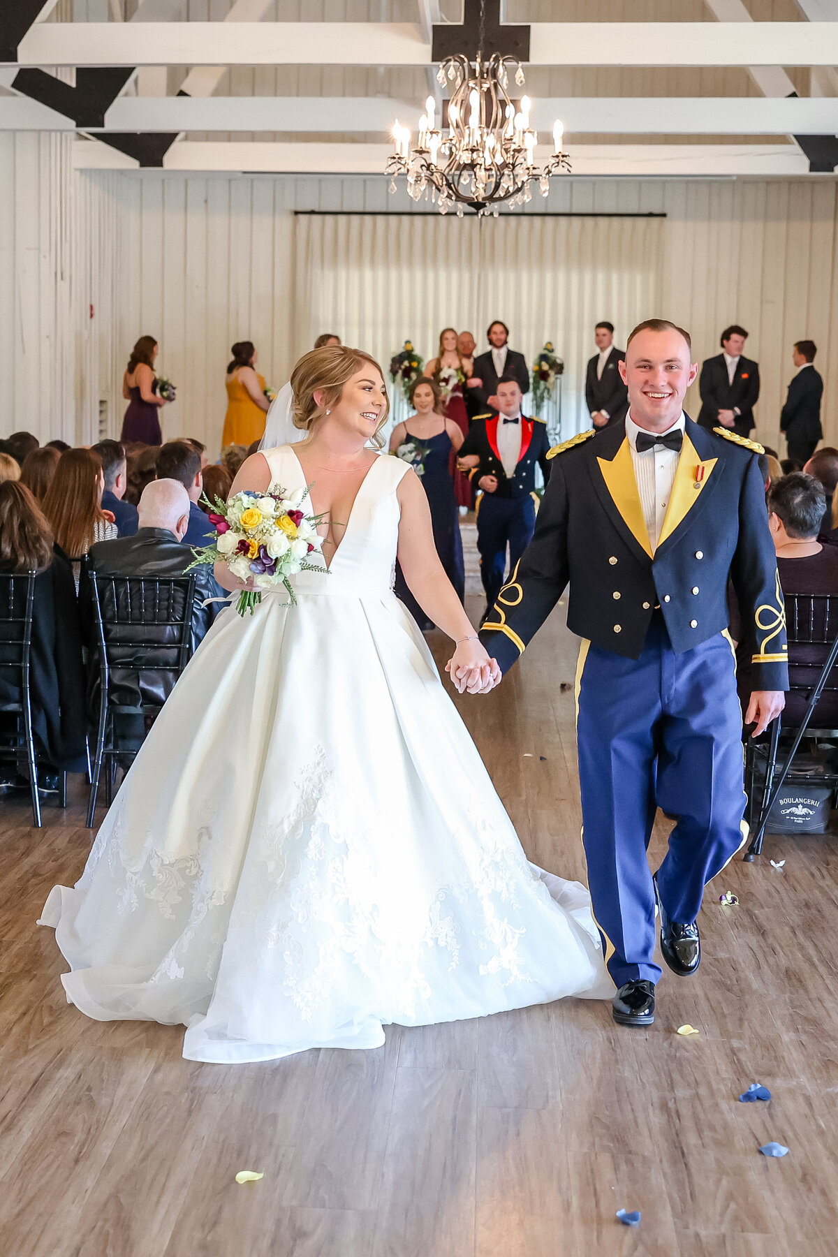 Aggie bride and groom walk from alter toward photographer  at Military wedding in Georgetown Texas