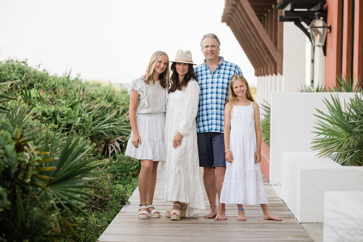 A family standing along a wooden path smiling