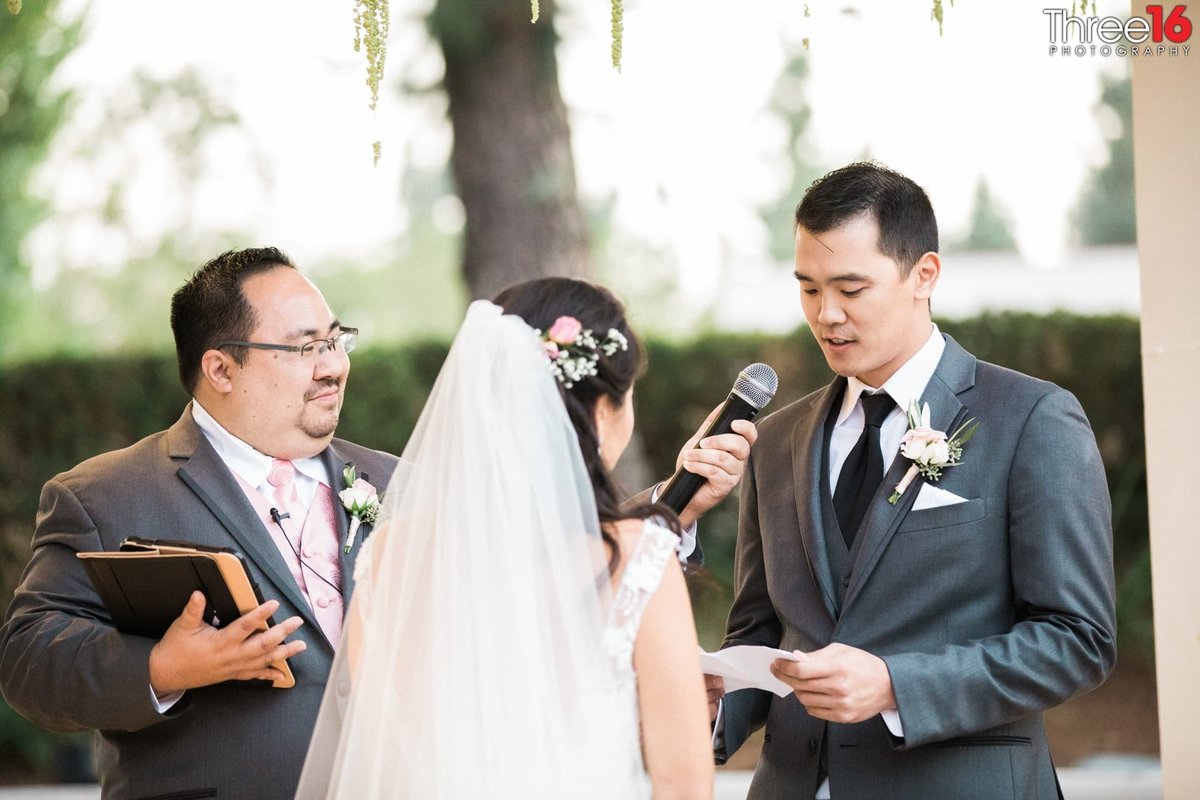 Groom reads his vows to his Bride into the microphone