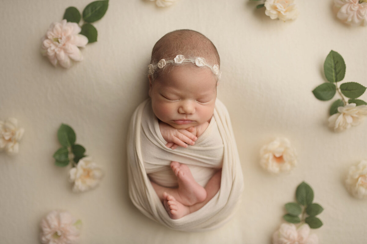 Boston newborn surrounded by flowers