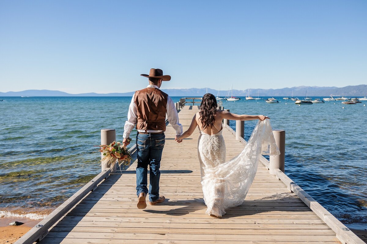 Newlyweds walking on dock at Lake Tahoe