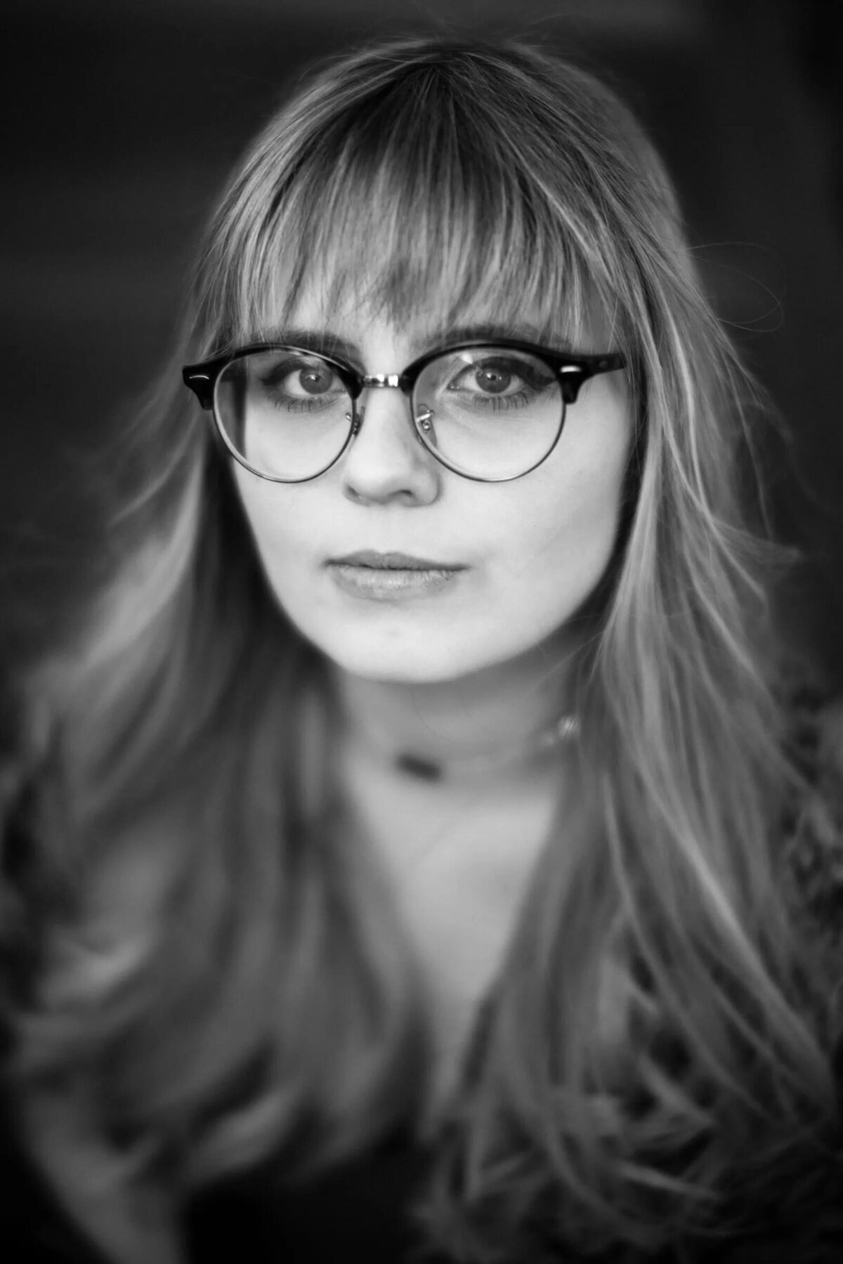 Black and white photo of a woman with large round glasses.