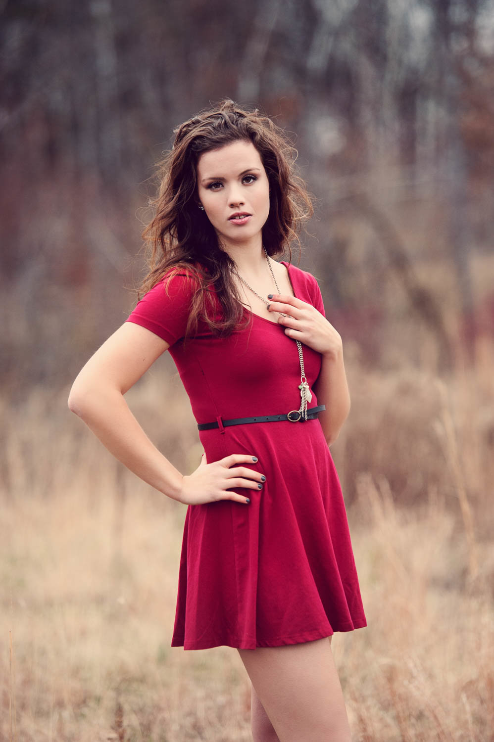 high school senior photo in red dress with fall grasses and trees