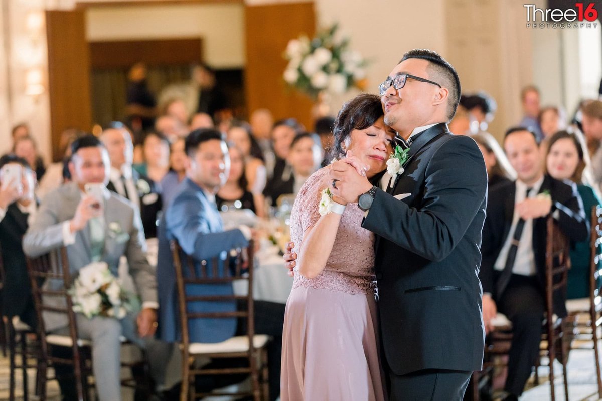 Groom dances with his mom at his wedding recpeiton