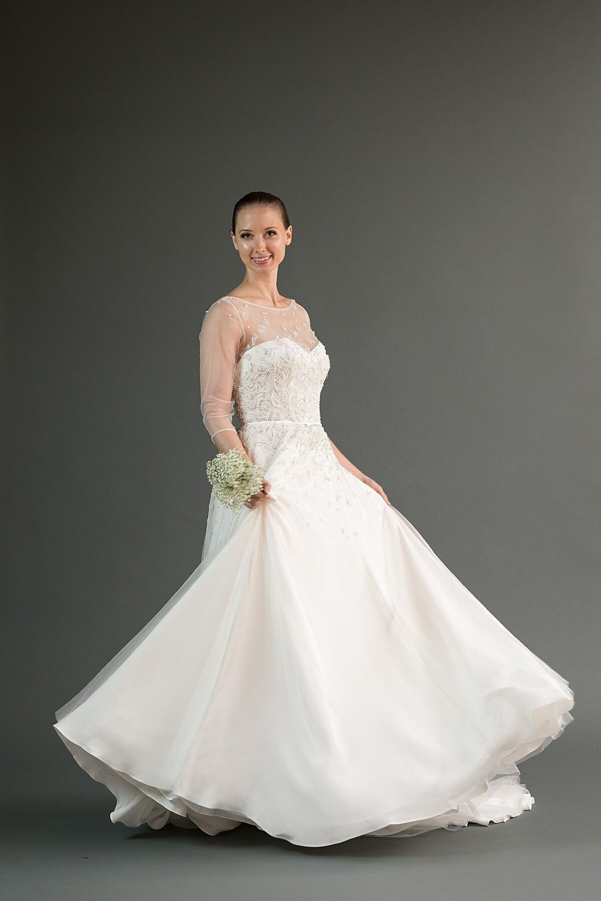 The a-line silhouette of the Rei wedding dress style twirls beautifully with its layers of skirt and pearl beaded tulle.