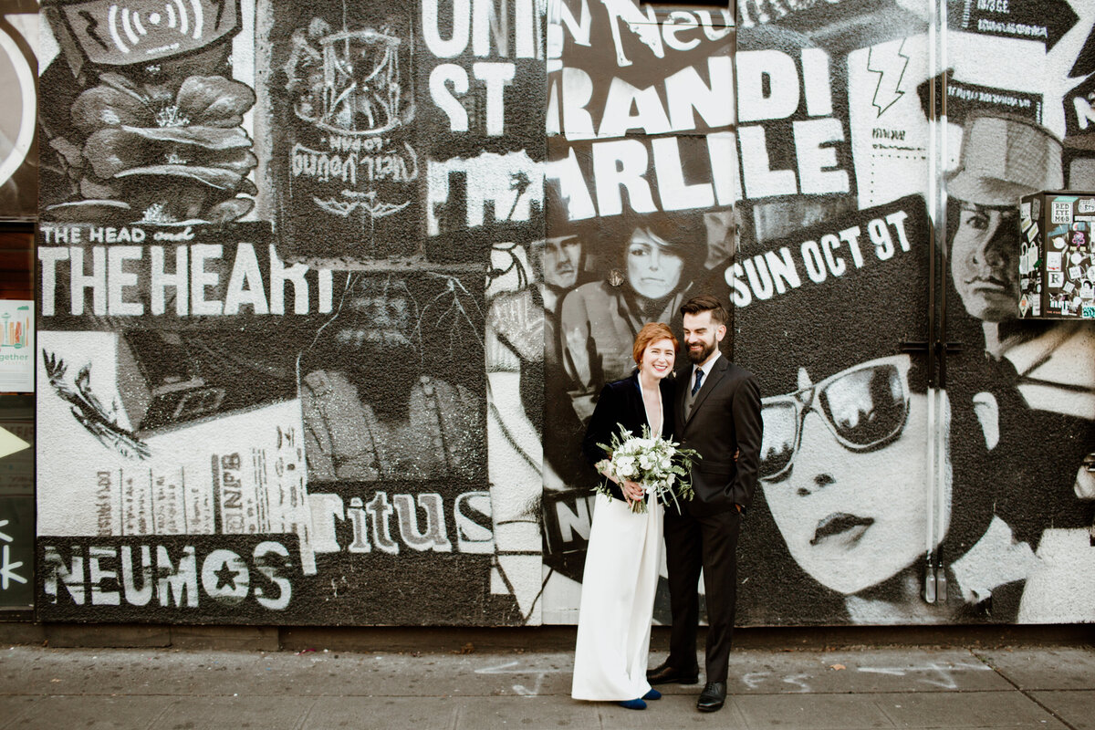 A bride and groom in front of a cool graffiti wall captured by Fort Worth wedding photographer, Megan Christine Studio