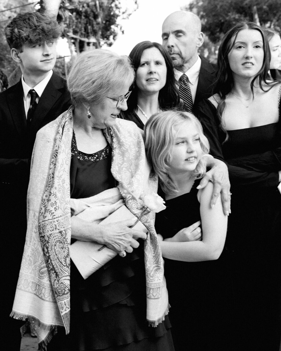 Black and white photo of wedding guests waiting outside at the Beverly Hills Hotel.