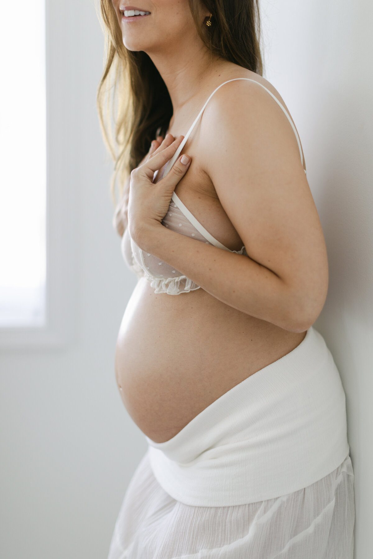 woman in a white Free People skirt during maternity session