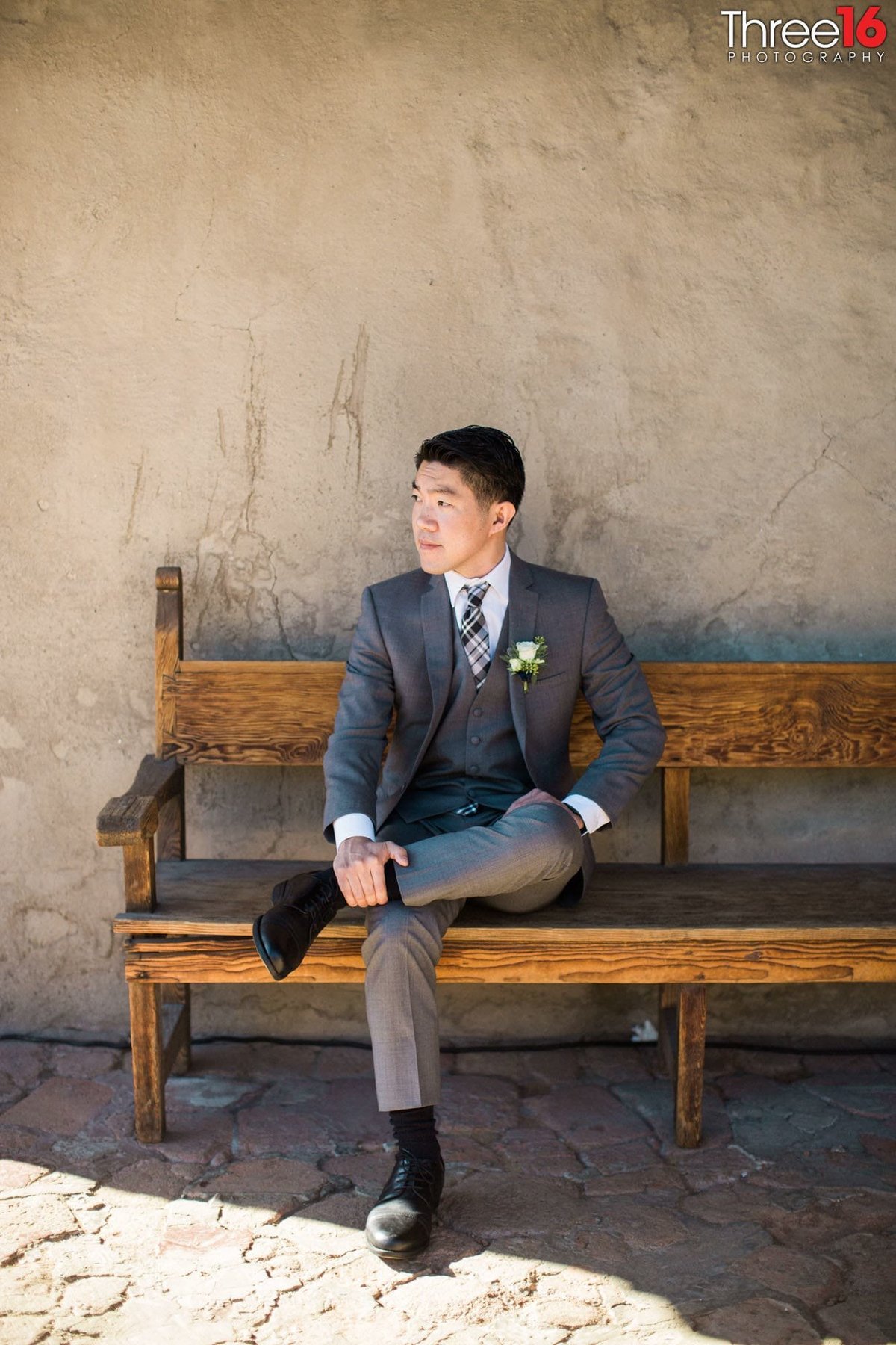 Groom sitting on wood bench contemplating before the wedding ceremony