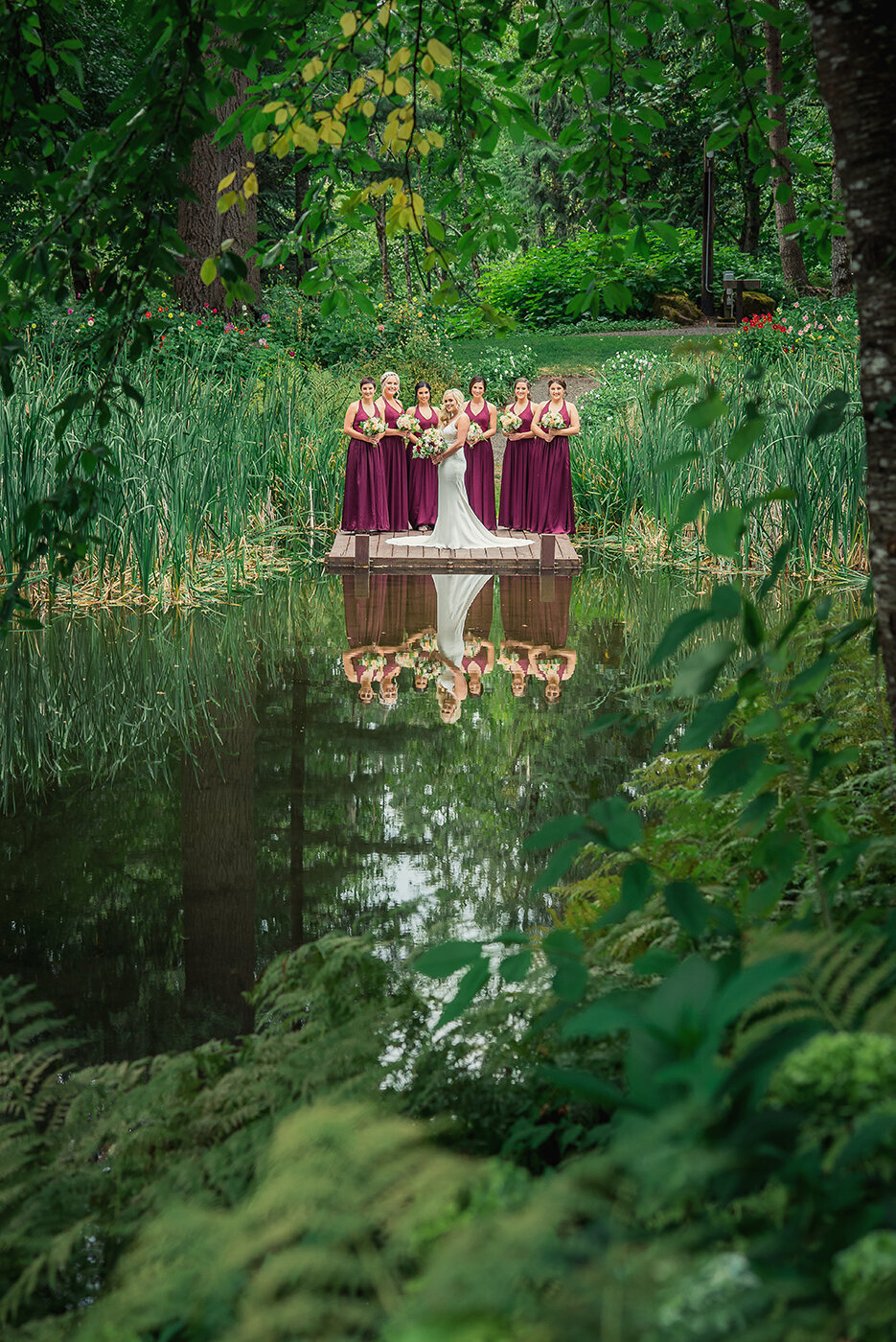bridesmaids reflected in water