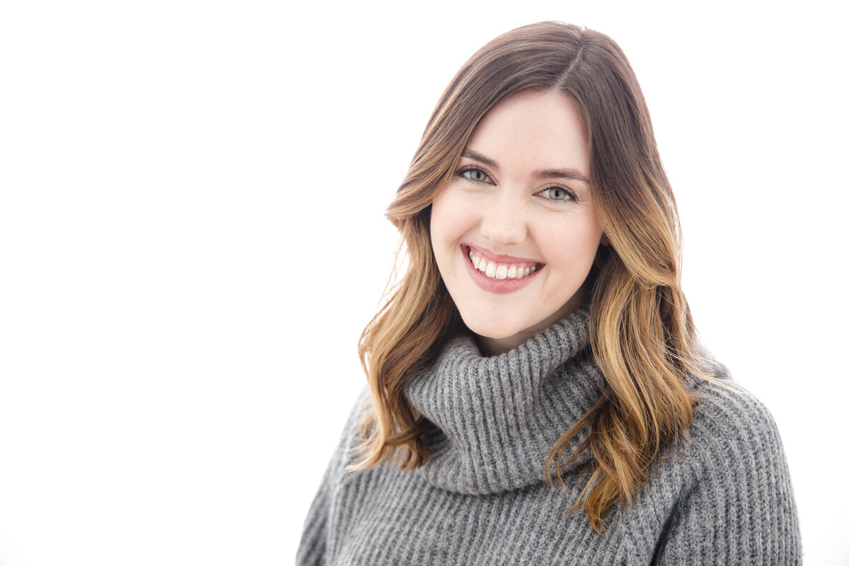 A woman in a turtleneck sweater smiling.