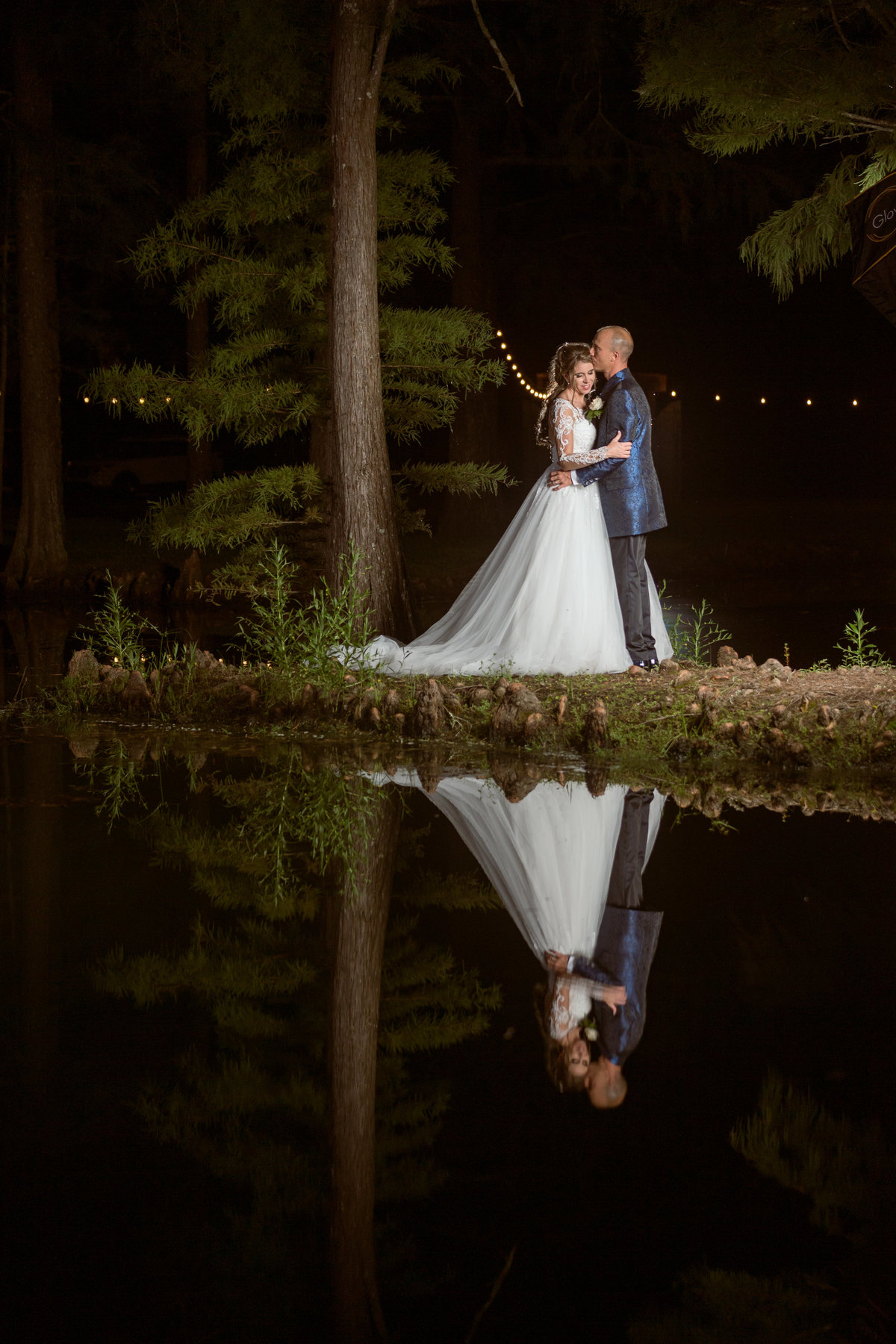 Bride & Groom in embrace by a pond.