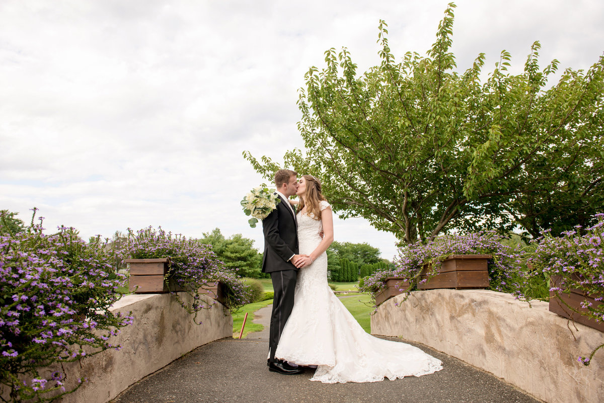 bride and groom kissing photo on bridge at Willow Creek Golf and Country Club