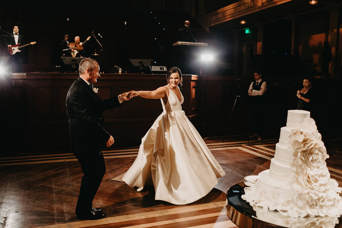 Father daughter dance with white petal wedding cake