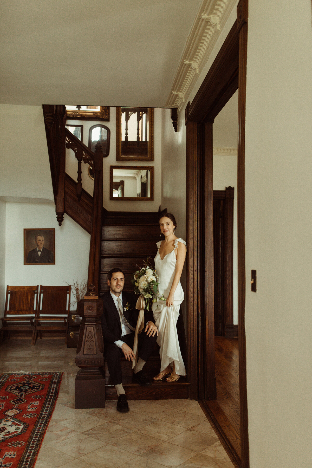 Bride and groom stand on stairs at The Kester Homestead