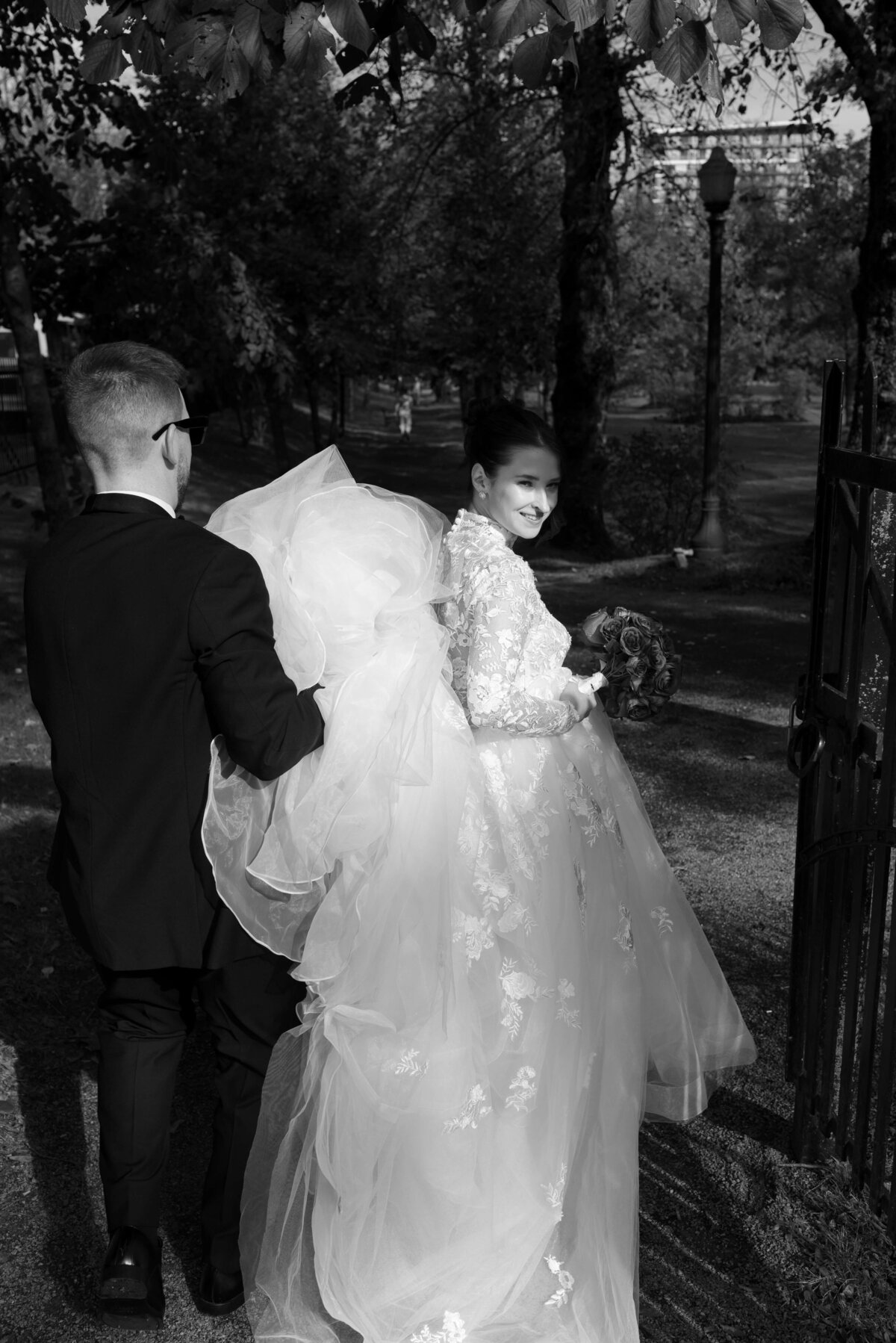 Bride walking out before wedding, having dress held up