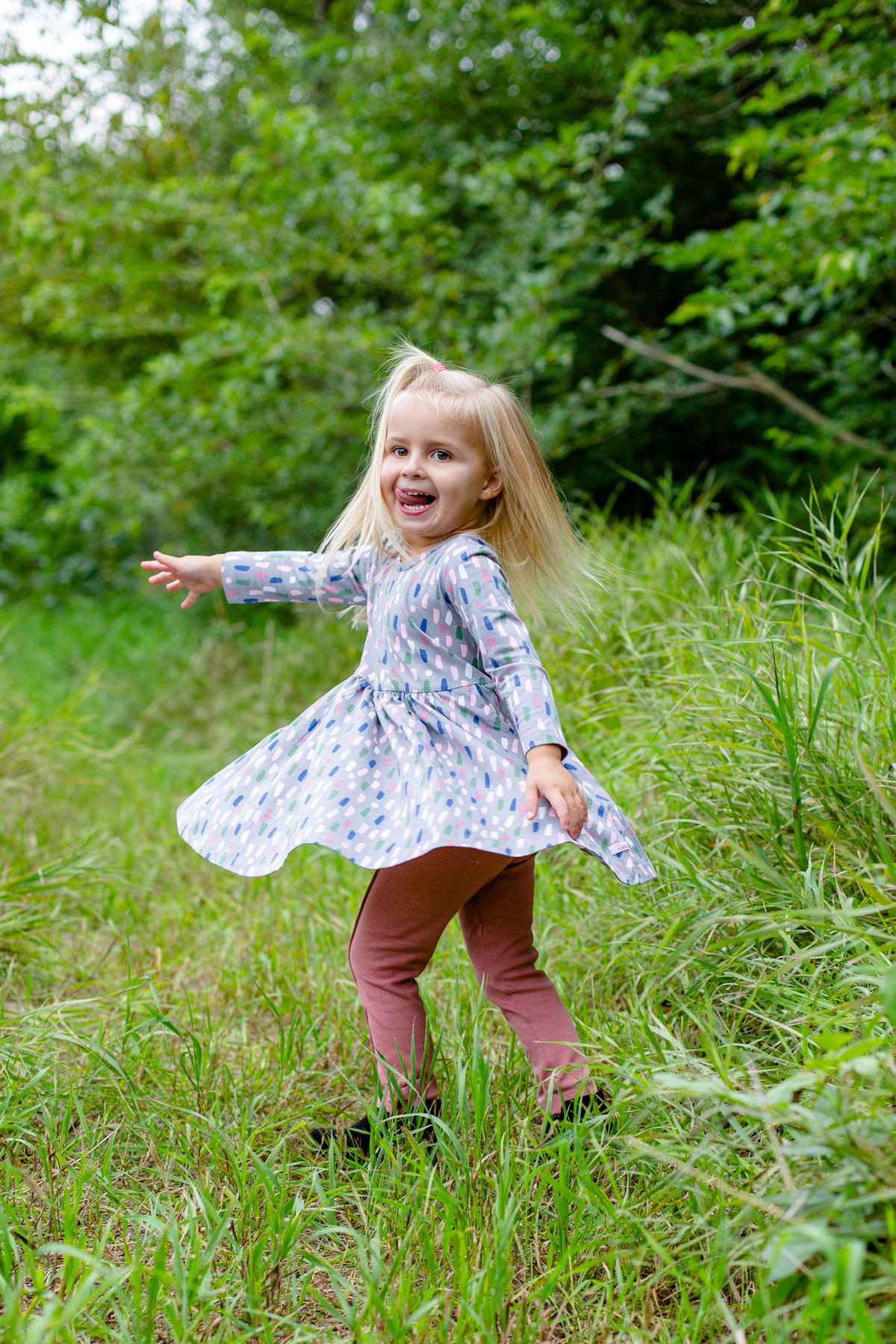 Happy child twirls in grass