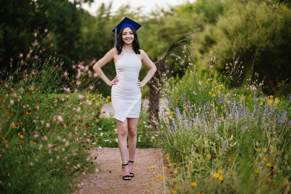 senior high school girl standing in flowers in San Antonio by high school senior photographer