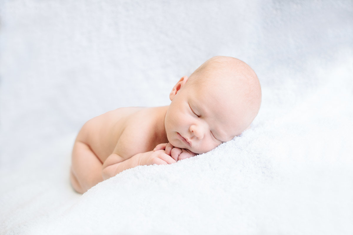 newborn baby on white blanket