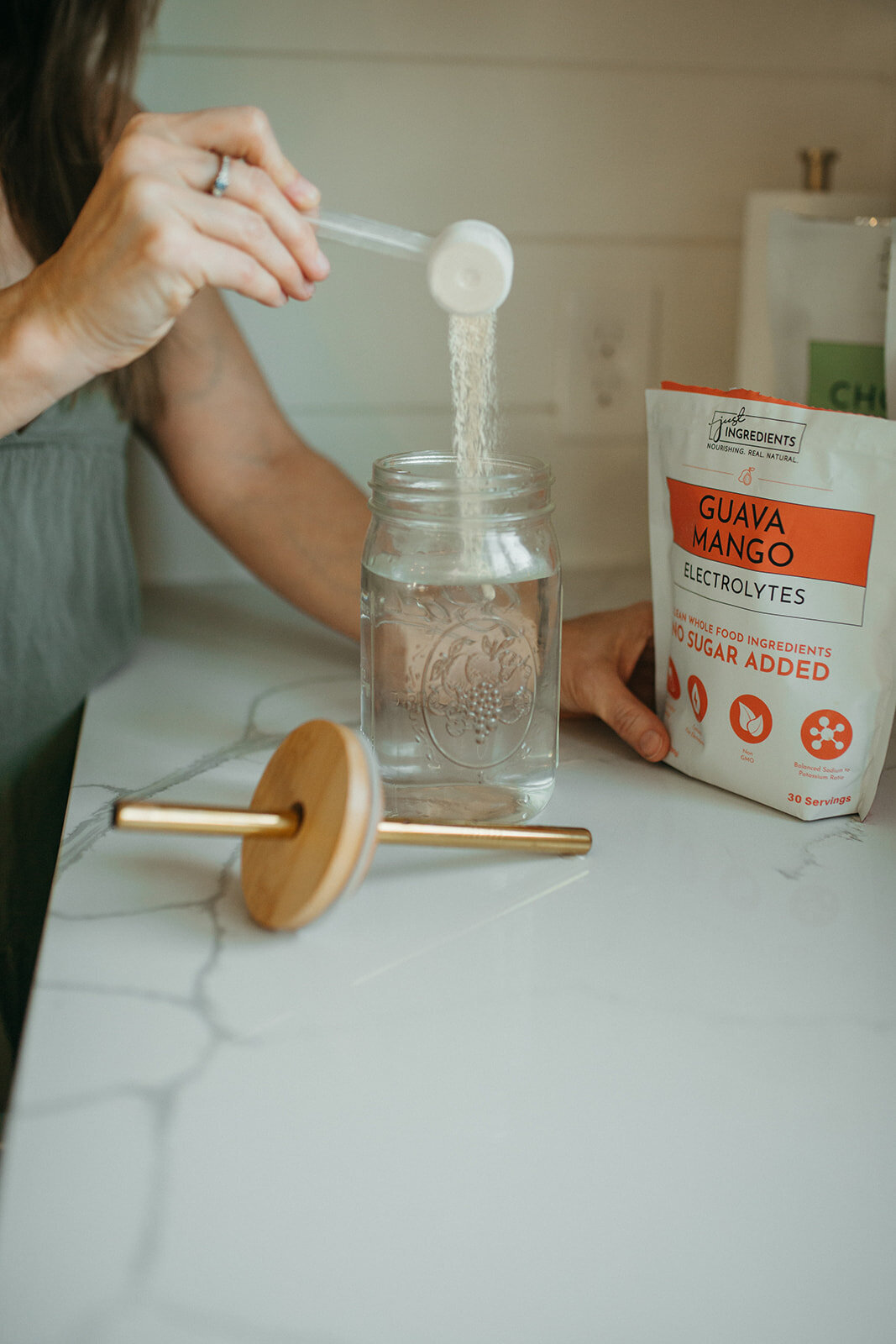 Natural cleaning products and a brush on a kitchen sink counter.