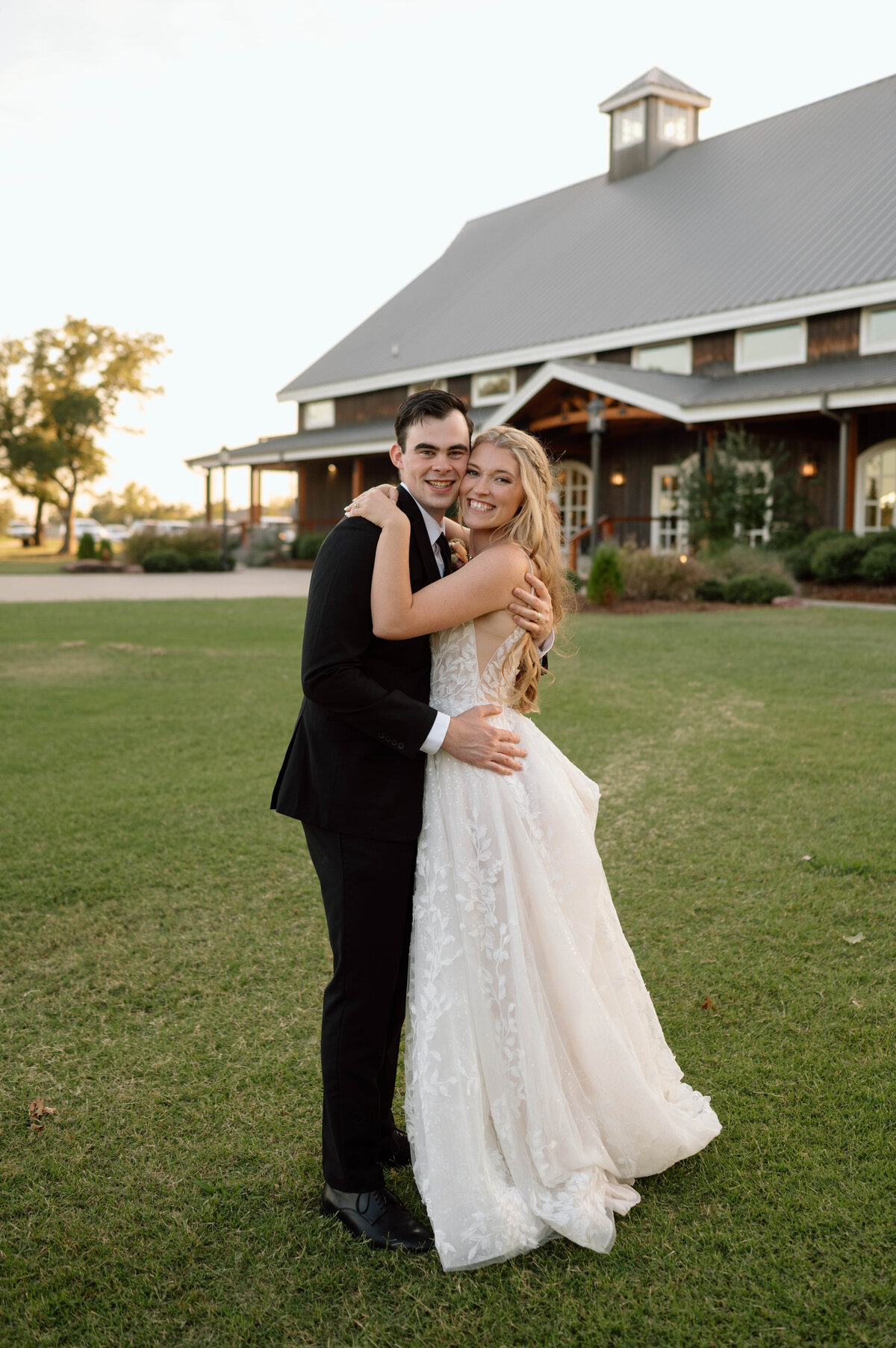 bride and groom smiling during sunset photos in stillwater ok on their wedding day