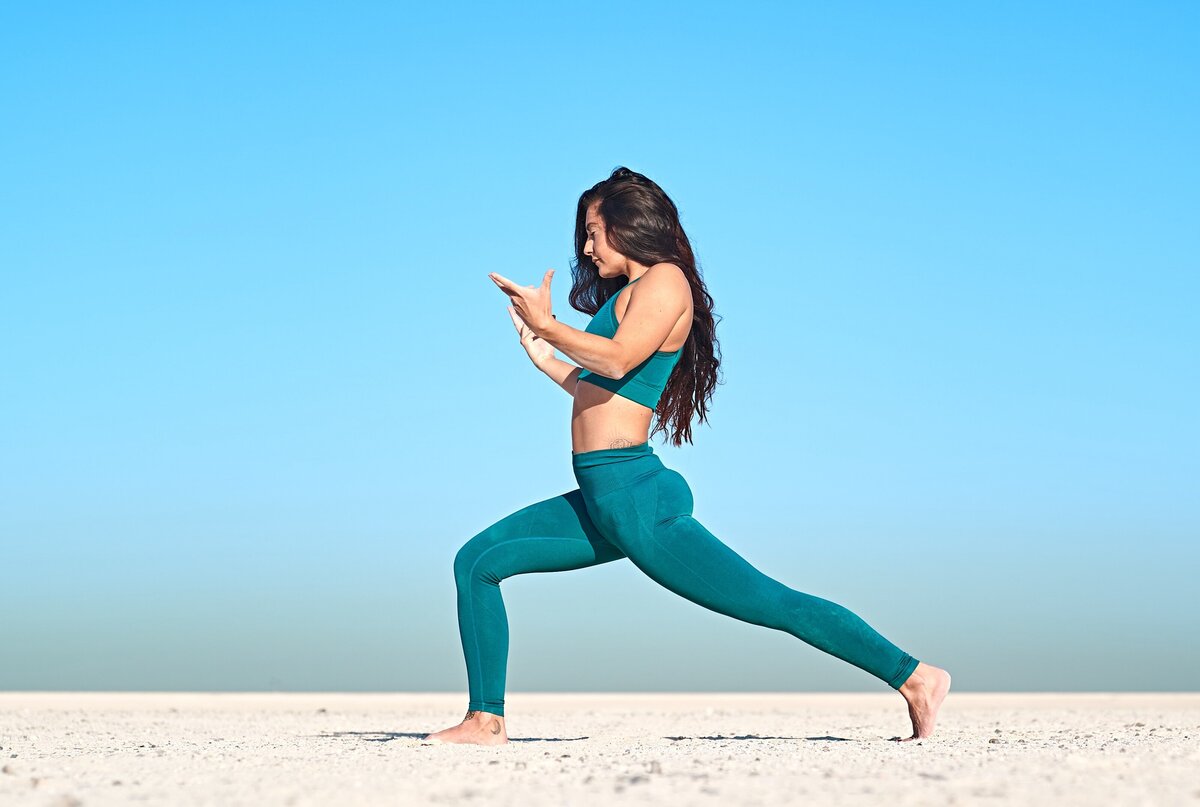 In the vastness of the desert, Sarah exemplifies elegance in a High Lunge Crescent pose, inspiring yoga instructors with her creative sequencing.