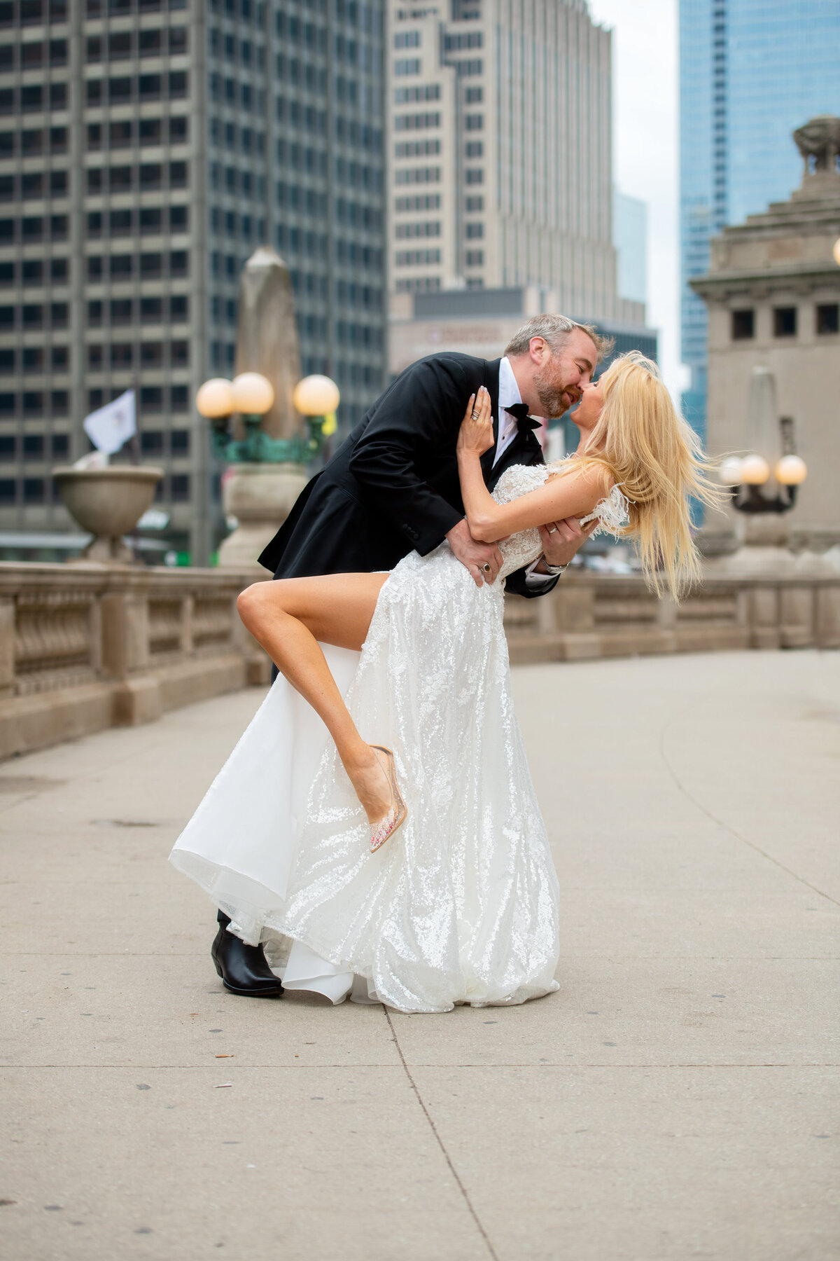 intimate kiss of bride and groom in the middle of Chicago riverwalk