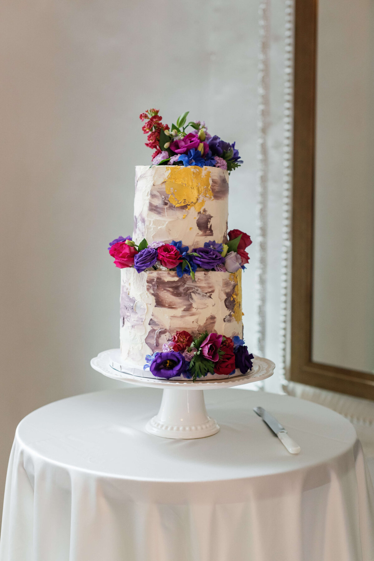 Two tiered wedding cake with colorful florals at  at Halifax Club wedding in Nova Scotia