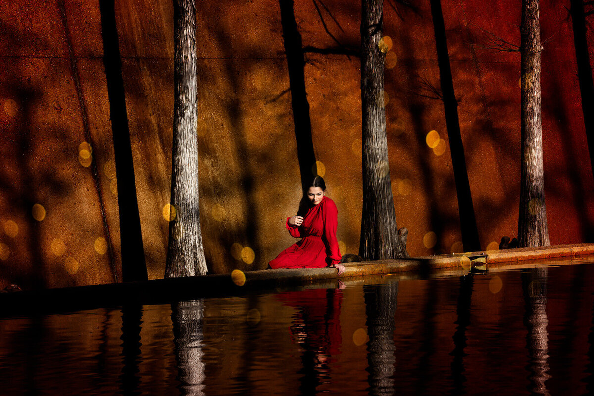 girl-in-red-dress-sitting-with-reflection-in-water