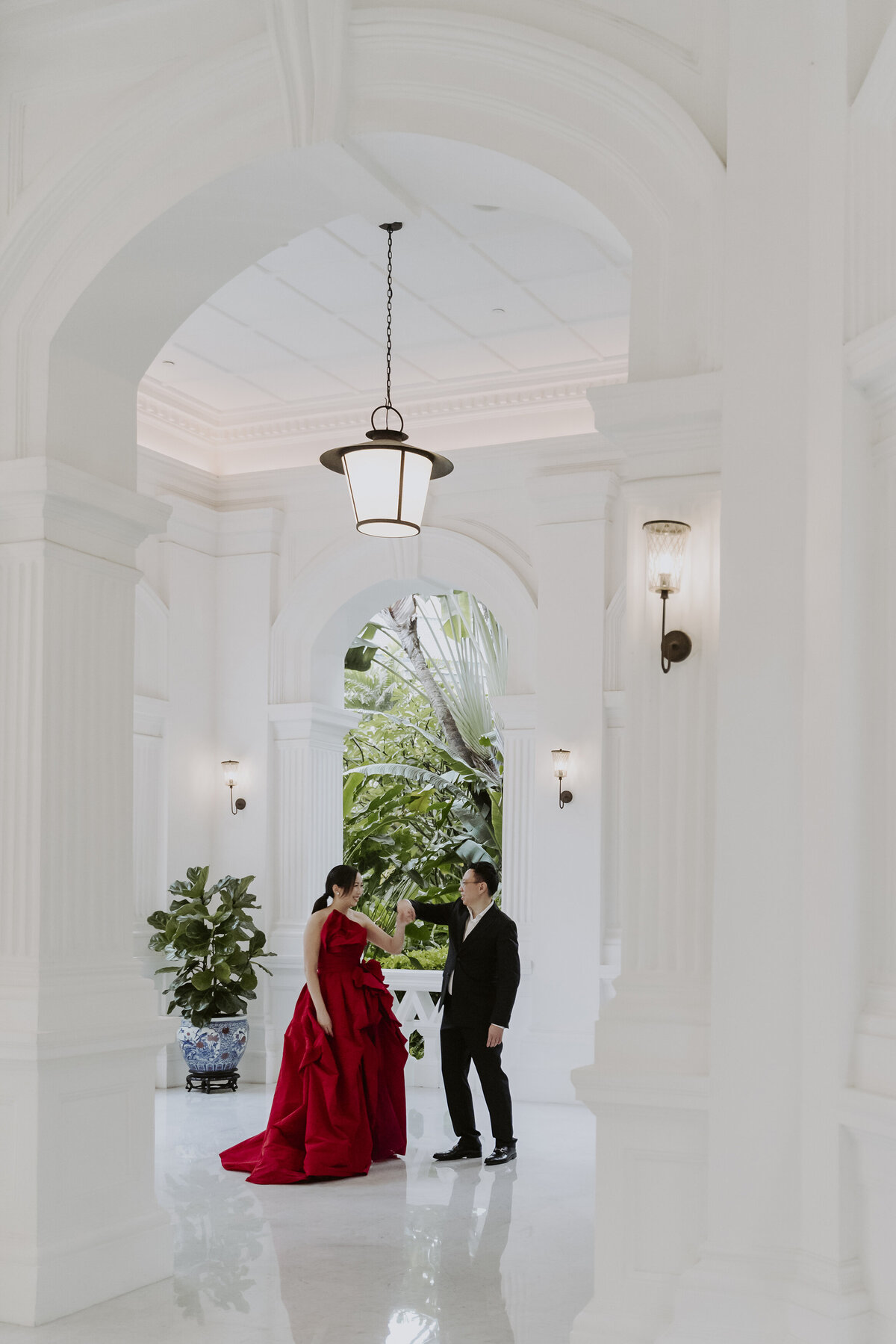 a couple dancing at the entrance of the raffles hotel