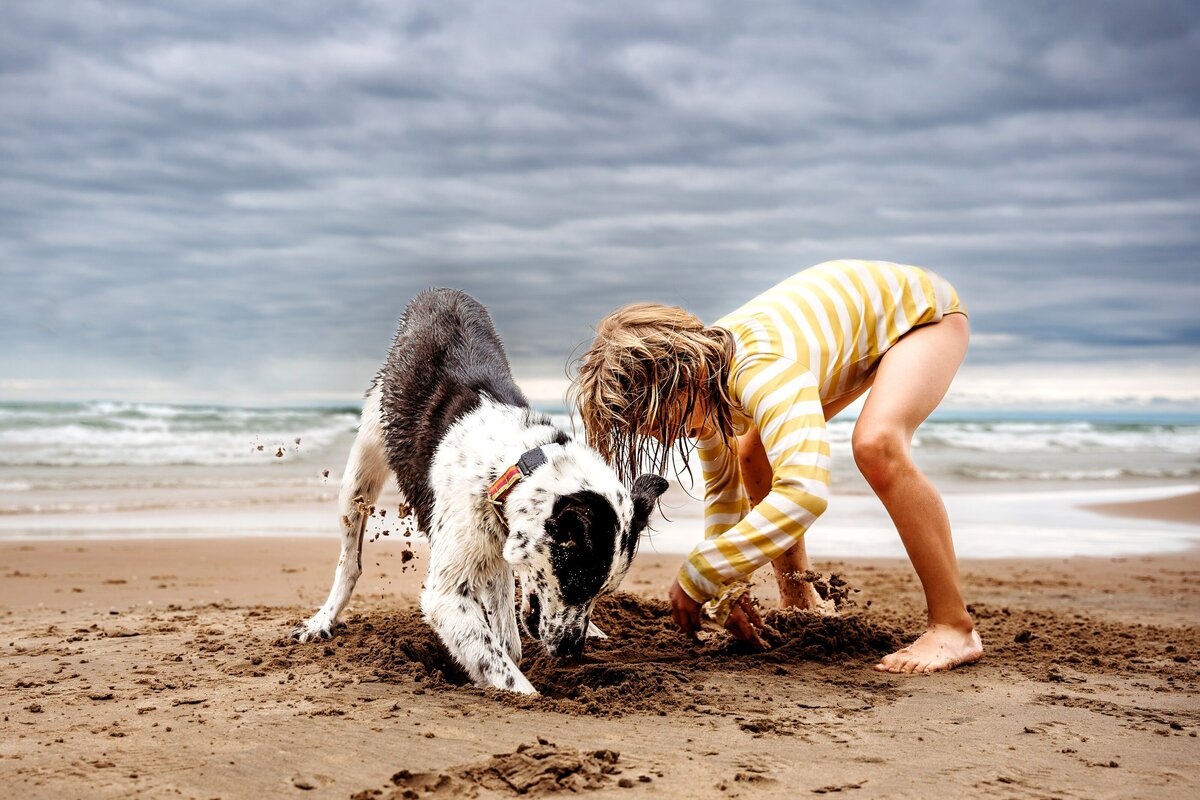 Child and dog digging in sand McKennaPattersonPhotography