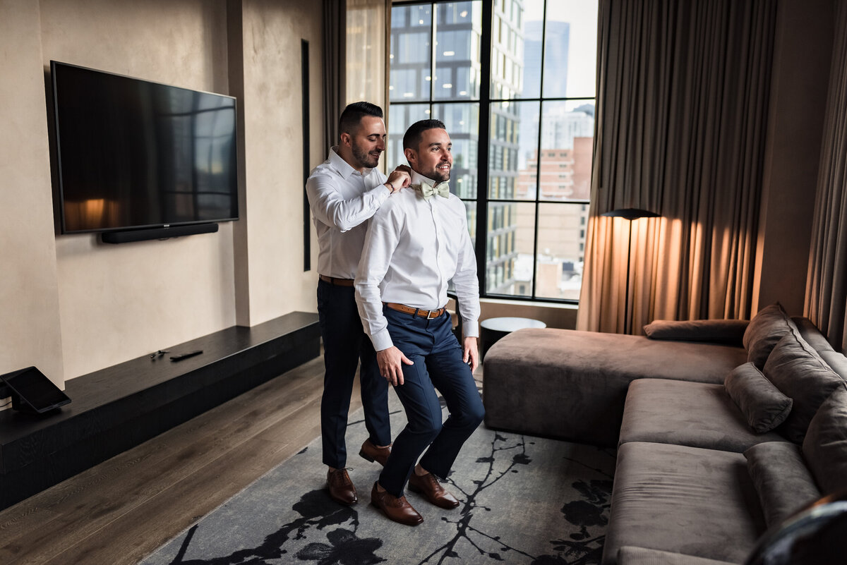 LGBQT couple help each other get ready for their wedding