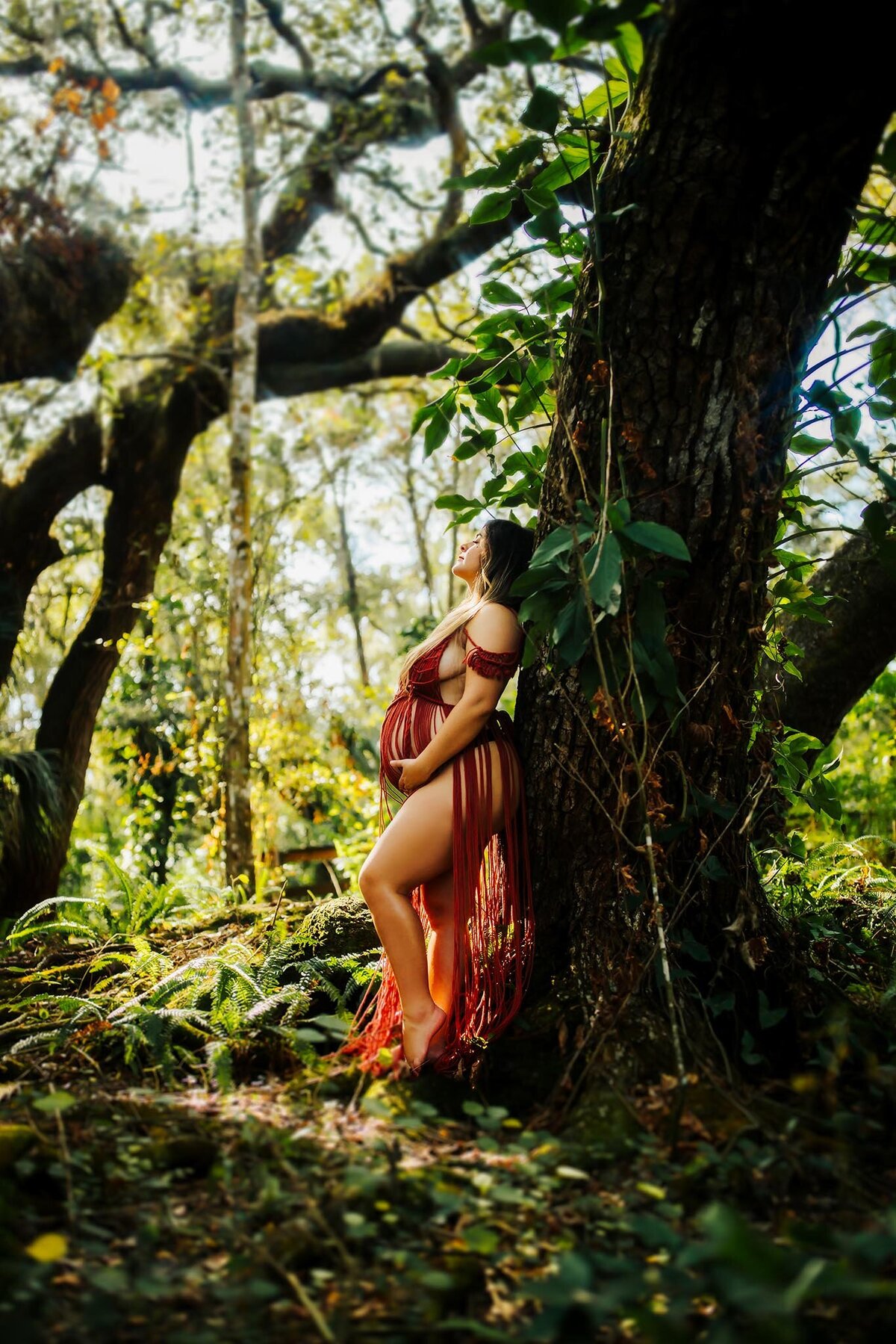 stunning pregnancy portraits of a women in a macrome dress surrounded by lush greenery at mocassin lake park fl