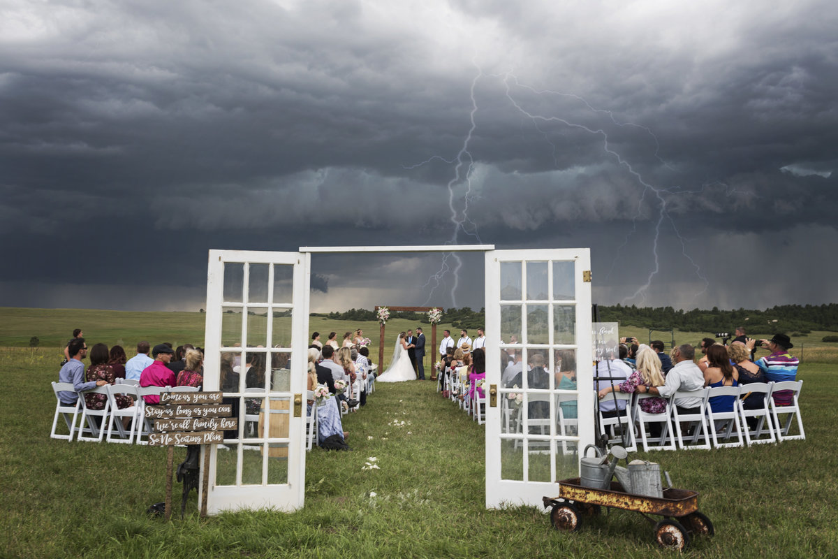 Lighting fills the sky at the weather changes at this wedding
