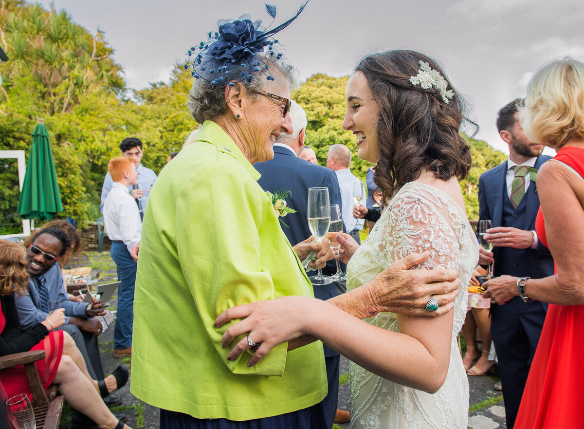 grandmother in lime green jacket and navy fascinator embracing her grand daughter wearing a vintage, beaded wedding dress in Kerry