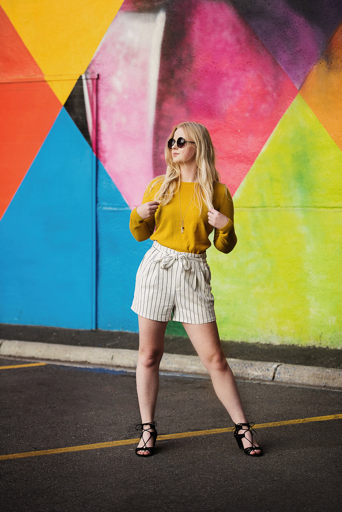 senior photo of fashion girl in front of rainbow mural wall in minneapolis