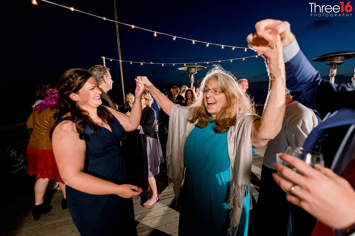 Guests dance at a Crystal Cove State Beach wedding reception