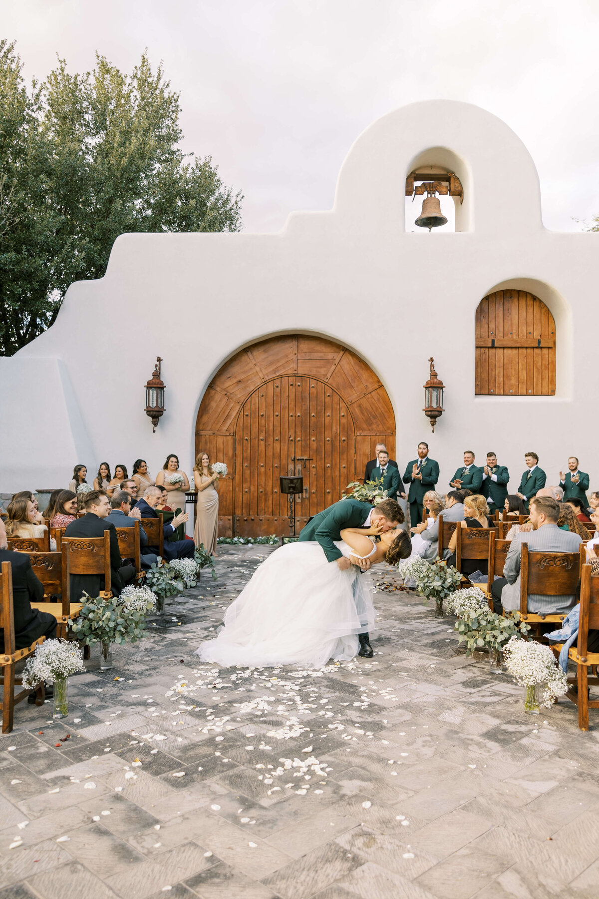 Groom dips his bride for a kiss in the aisle after getting married at the gorgeous tubac golf club resort