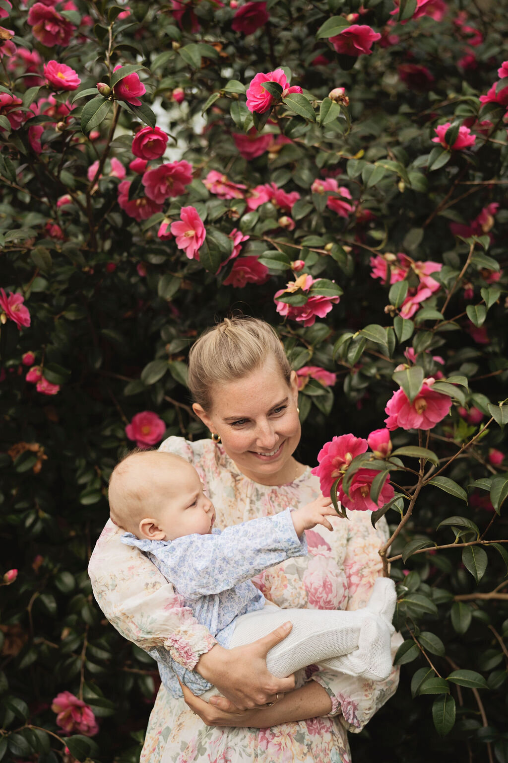 Mother and baby girl with pink camilia flowers at Chiswick House Gardens photo shoot