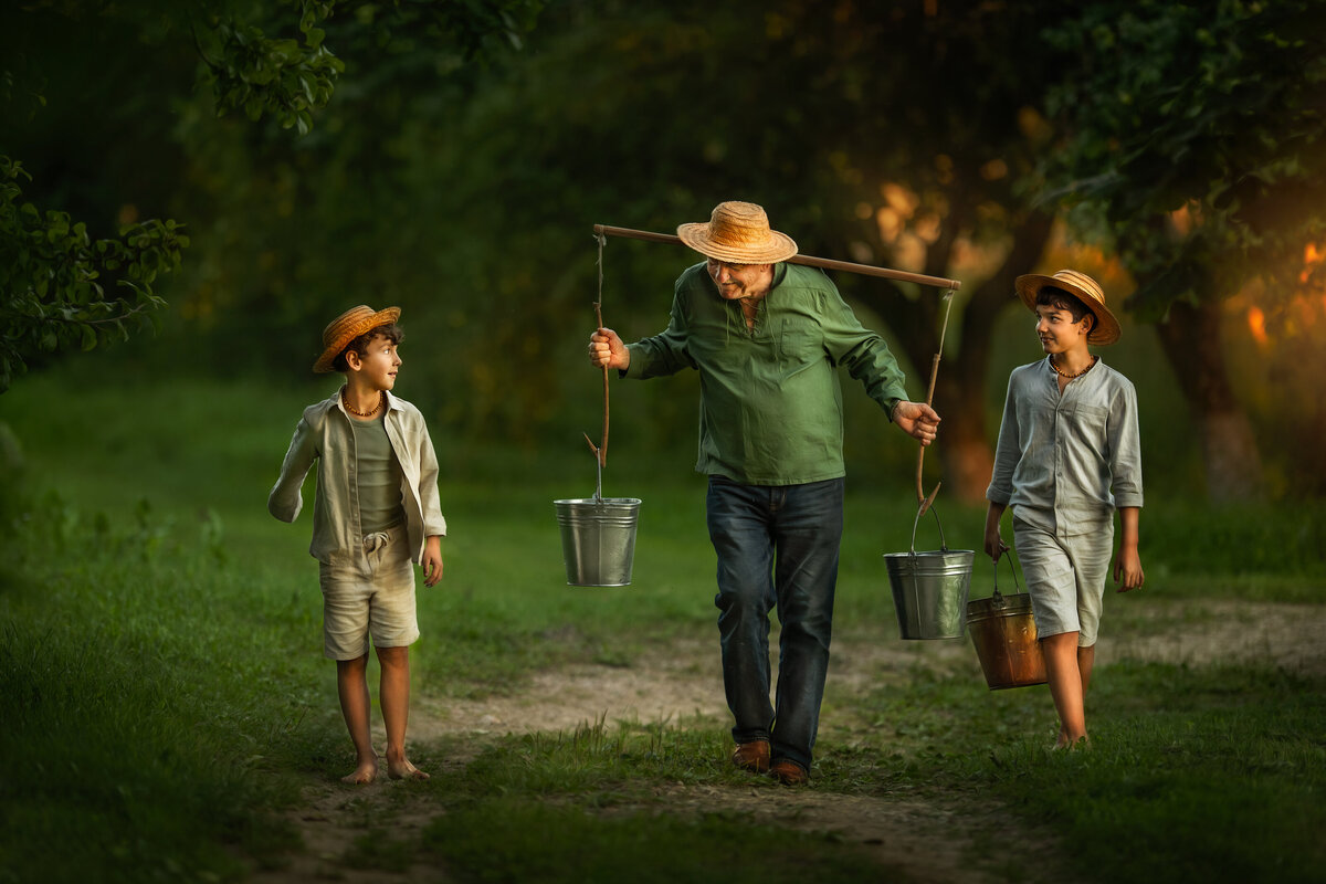 Grandpa and grandkids  getting water from the well  in straw hats