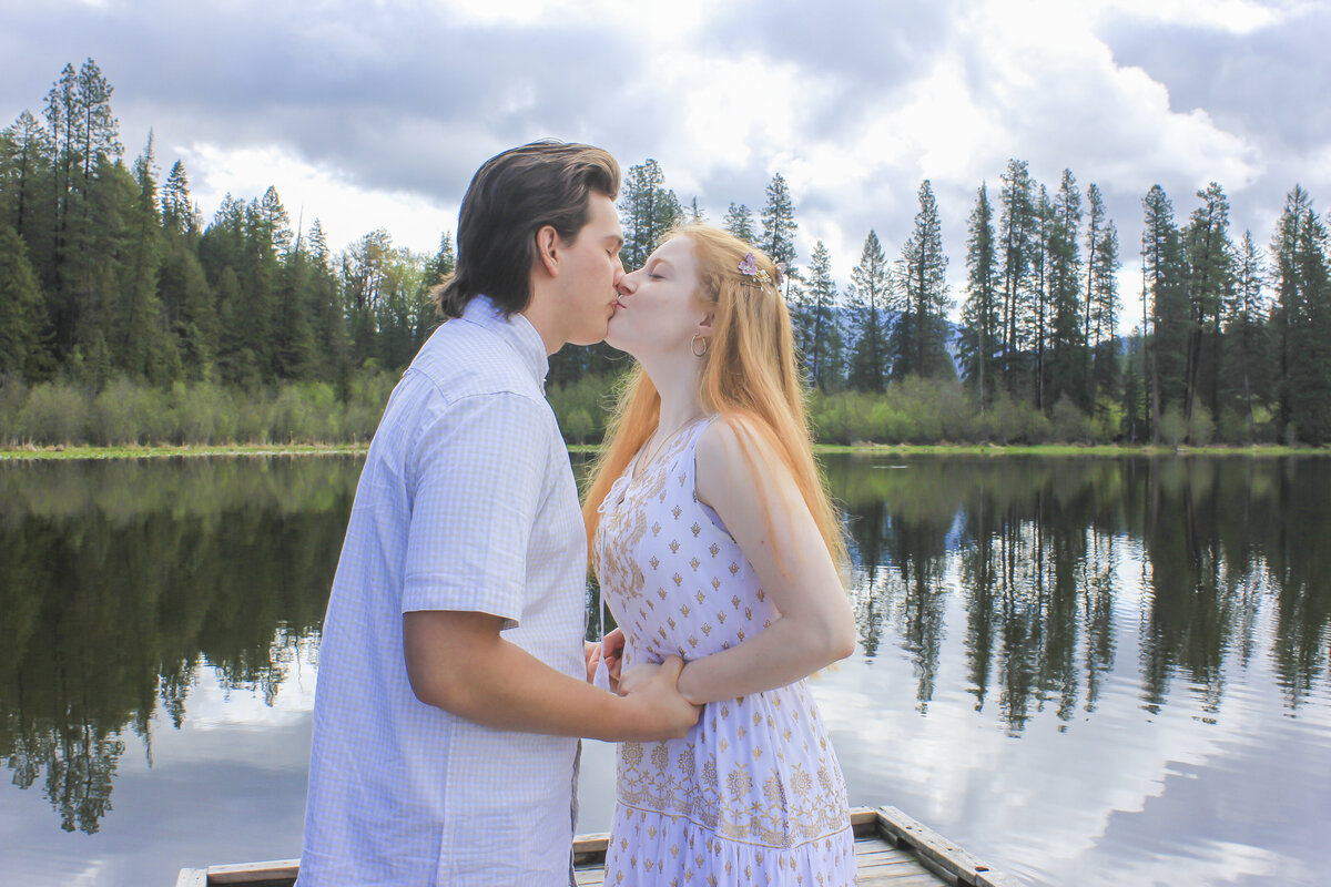 Newly Engaged Couple near lake kissing
