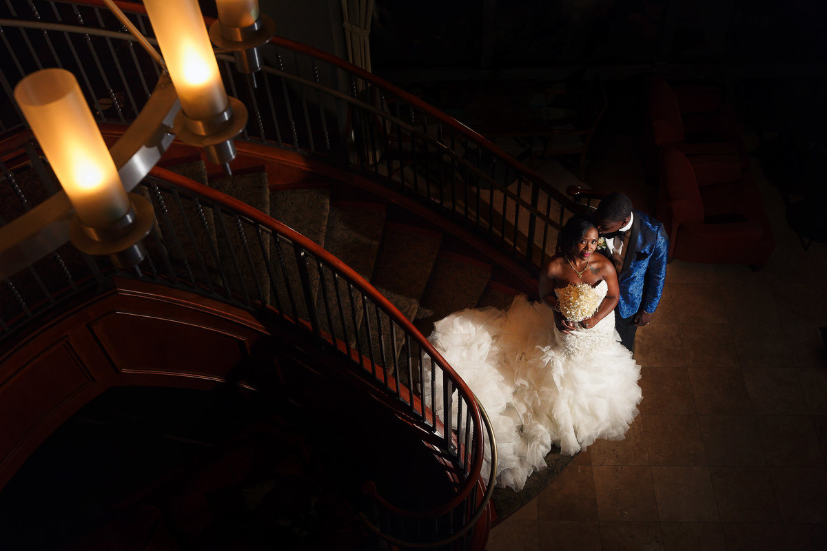 Bride and Groom Pictured from Above at the Bottom of a Staircase at their Romantic Wedding at the River Club in Jacksonville