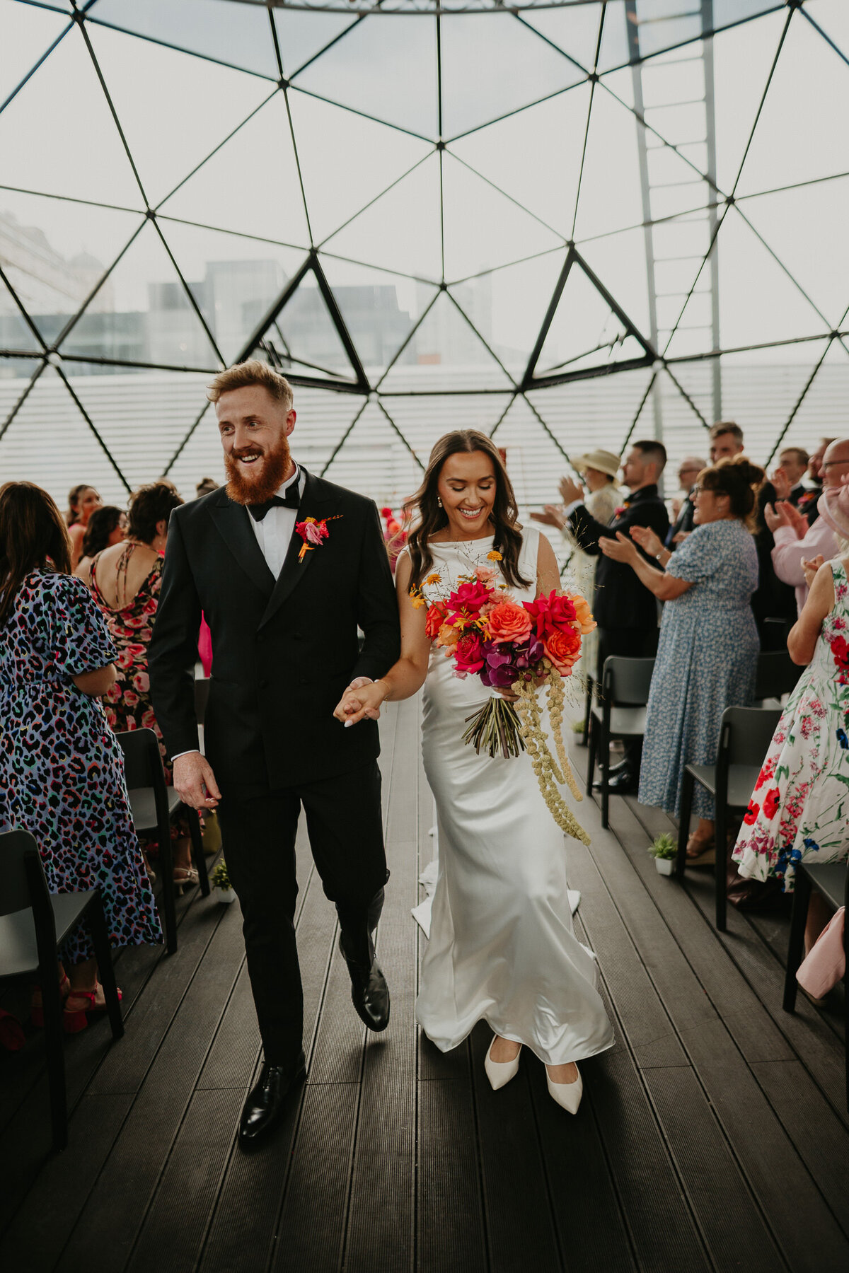 Bride and Groom walk up the aisle at their wedding ceremony at The Dome at ABC Buildings in Manchester.