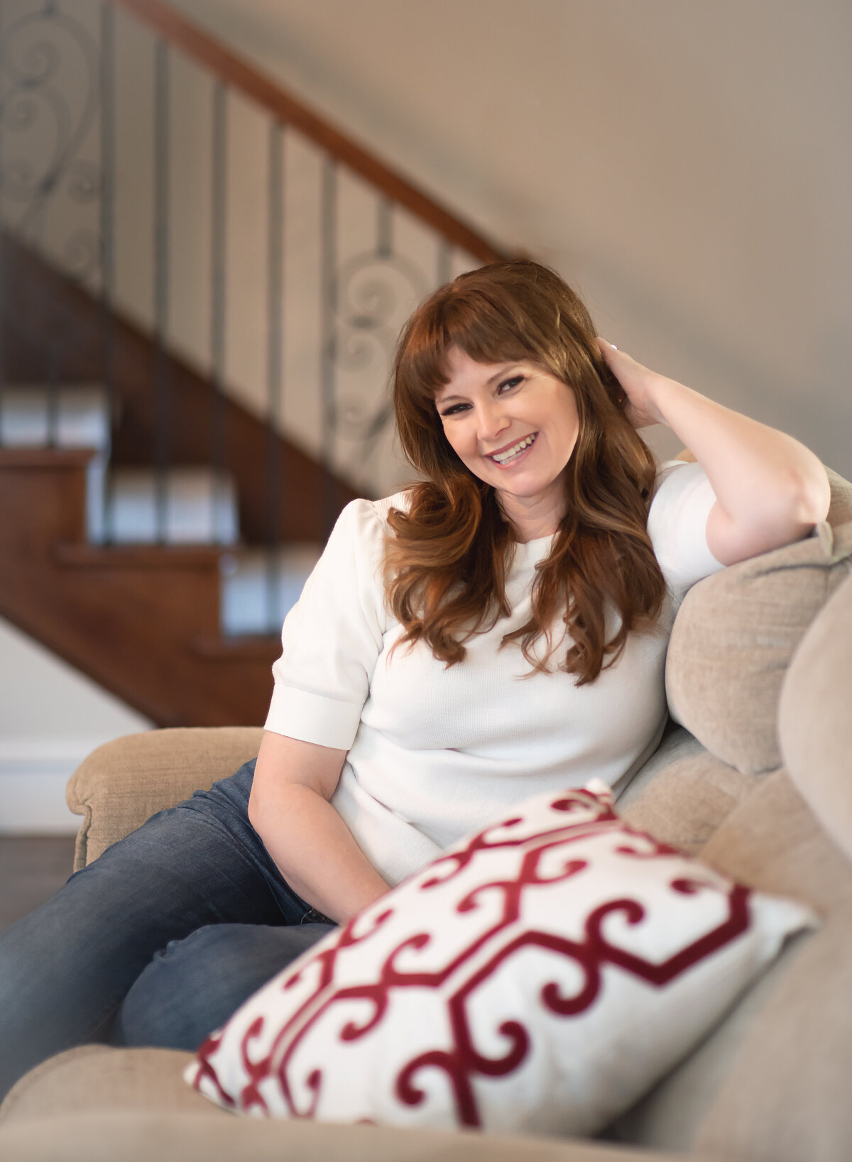 personal branding headshot of woman on her couch looking friendly and approachable
